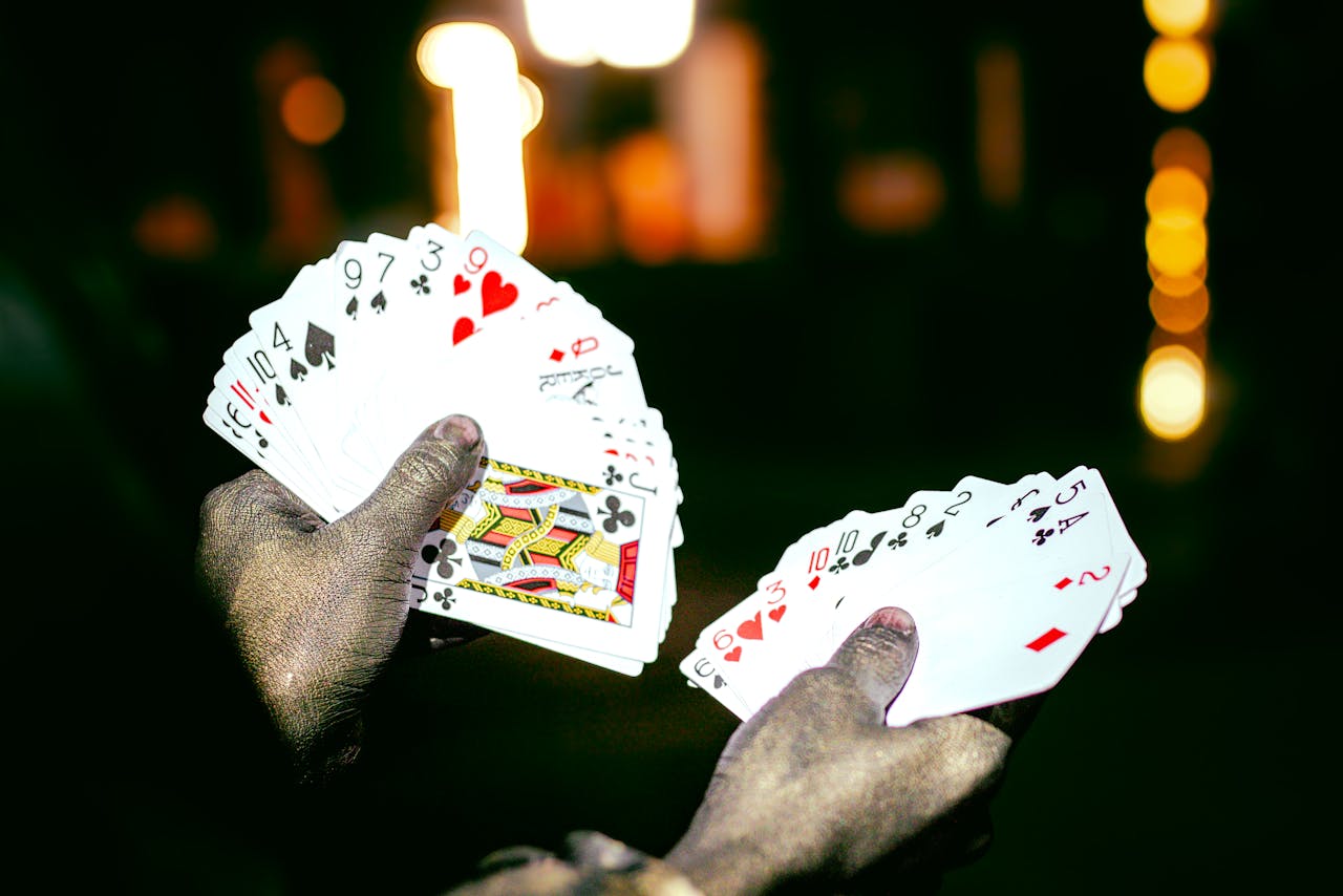 A magician showcases a deck of playing cards with dramatic lighting at night, highlighting a sense of mystery and intrigue.